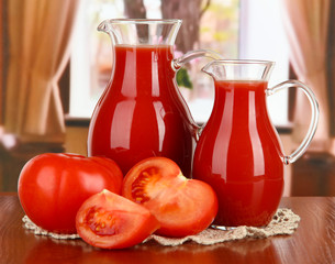 Tomato juice in pitchers on table in room