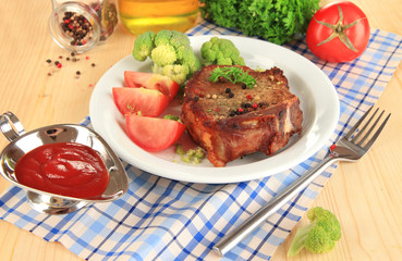 Piece of fried meat on plate on wooden table close-up