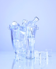Minibar bottles in bucket with ice cubes, isolated on white