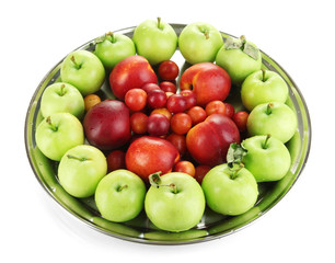 Assortment of juicy fruits on plate, isolated on white