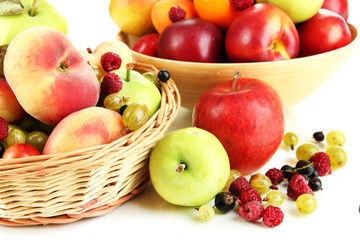 Assortment of juicy fruits in wicker basket and wooden bowl,