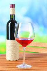 Glass of wine on wooden table  on nature background