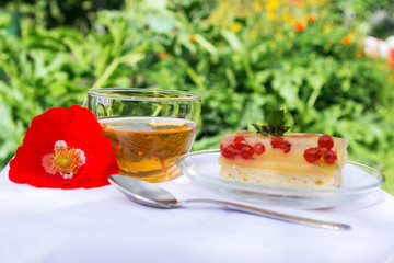 Tasty tea cake and poppy flower on white cloth