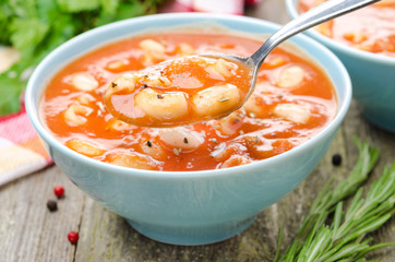 spoon of tomato soup with pasta, white beans and rosemary