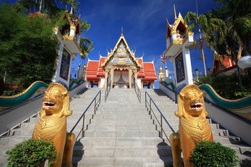 Golden lion guarding statues in Thai temple