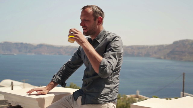 Happy man drinking cocktail on beautiful terrace