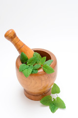 wooden mortar with melissa leaves