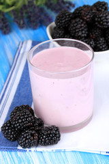 Fototapeta na wymiar Sweet blackberries with yogurt on table close-up