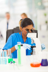 young scientist looking through microscope