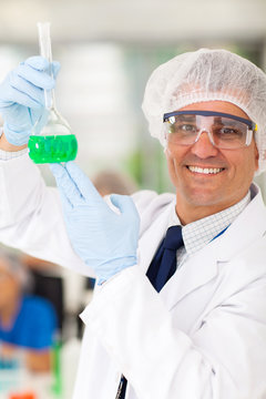 senior medical researcher holding a flask