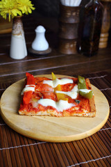 Vegetarian pizza with peppers, tomatoes and cheese on wood table