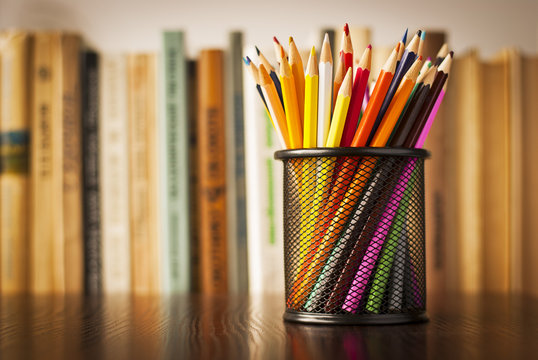 Wire desk tidy full of coloured pencils