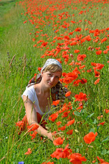 The young woman among red poppies