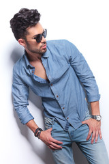 casual man looks to side with thumbs in pockets