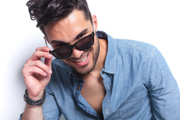 casual man takes off sunglasses