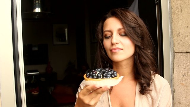 Young Woman Eating the blackberry Cake