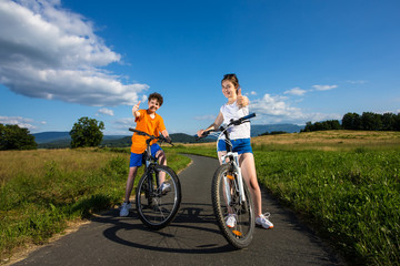 Naklejka premium Healthy lifestyle - teenage girl and boy biking