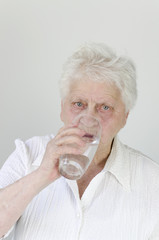 Seniorin über 80 trinkt Wasser