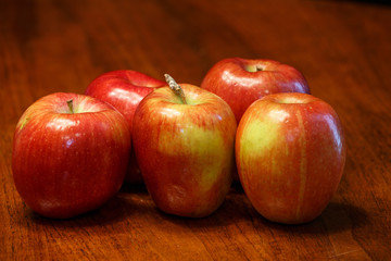 Five Red Apples on Wood Table