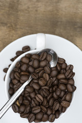 Cup of coffee and beans on wooden background