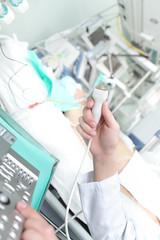 Doctor holding an ultrasound probe in the ICU.