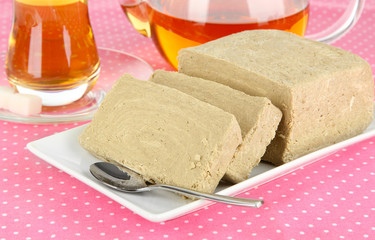 Tasty halva with tea on table close-up