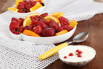 Useful fruit salad in plates on wooden table close-up