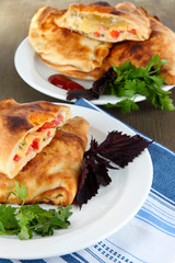 Pizza calzone on plates on napkin on wooden table