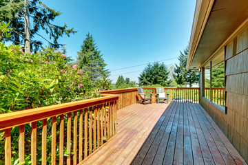 Long Deck, terrace with wood railings and green landscape.