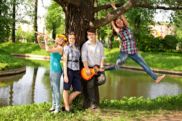 Naklejka na ściany i meble teenagers have fun in the park, playing guitar, singing son