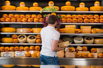 Handsome male owner of a cheese store working
