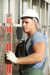 builder facade plasterer worker with level