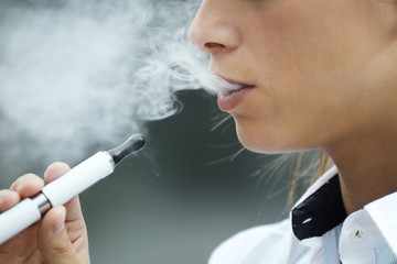 closeup of woman smoking electronic cigarette outdoor - obrazy, fototapety, plakaty