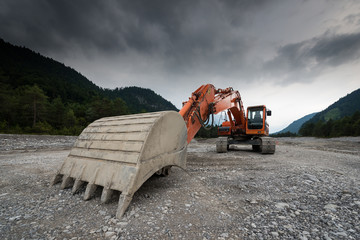 perspective of digger power shovel in red on gravel