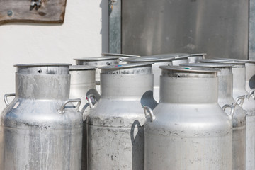 several empty silver cow milk cans with cap