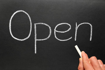 Open written in white chalk on a blackboard.