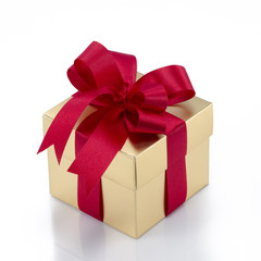Beautiful gold present box with red bow and ribbons