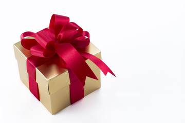 Beautiful gold present box with red bow and ribbons