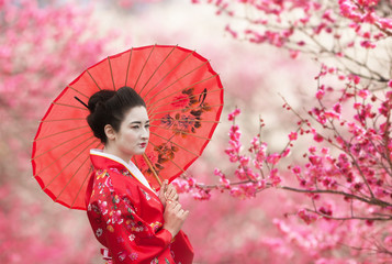 Asian style portrait of a woman with red umbrella