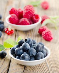 Blueberries and raspberry on wooden table