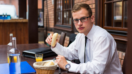 Fototapeta na wymiar Smiling Businessman sitting with smartphone in restaurant.