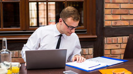 Hard working businessman in restaurant. Close-up.