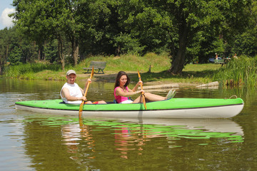 Young couple kayaking summertime  in the sunshine vacation