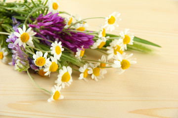 Obraz premium Wild flowers and green spikelets, on wooden background