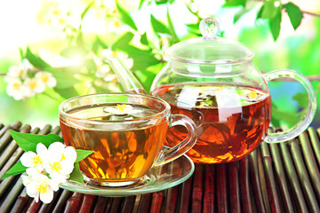 Cup of tea with jasmine, on bamboo mat, close-up