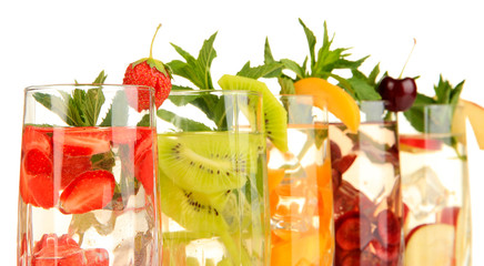 Glasses of fruit drinks with ice cubes isolated on white