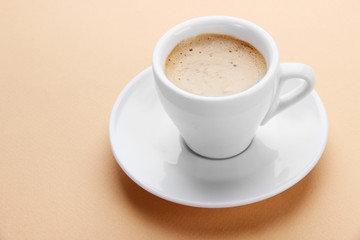Cup of coffee on beige background