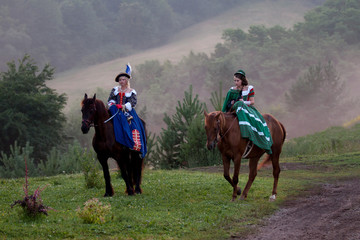 Two women in the royal baroque dress riding
