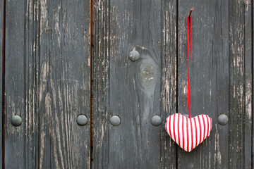 Vintage wooden wall with love heart hanging on nail