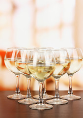 White wine in glass on room background